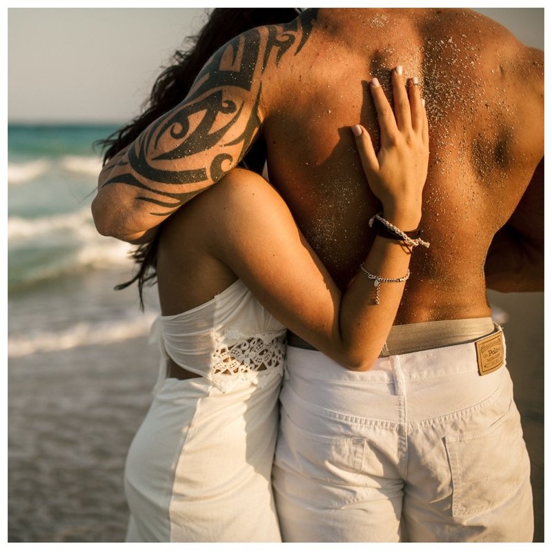 Couple with tattoos on the beach.