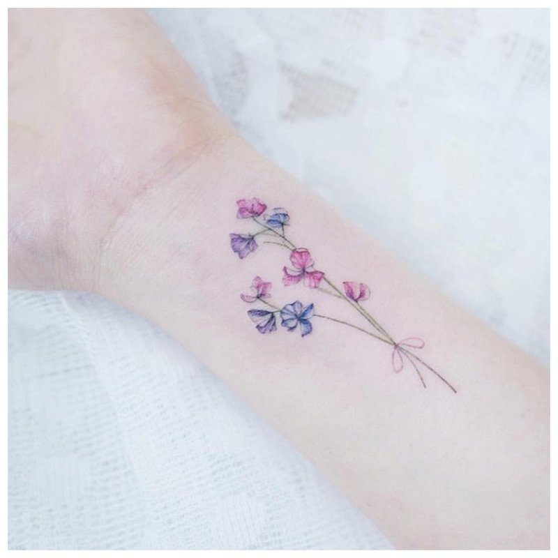 Small flower on hand - tattoo