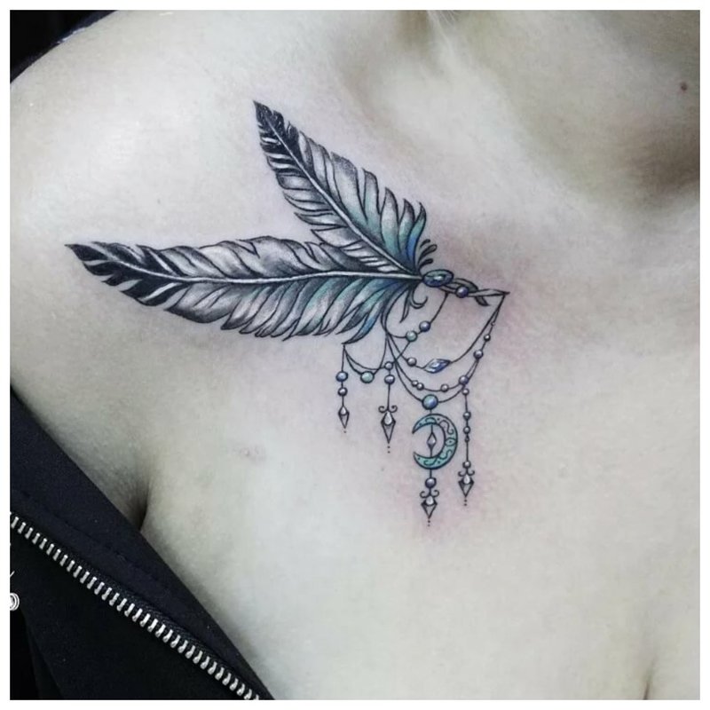 Bright tattoo feather on the collarbone