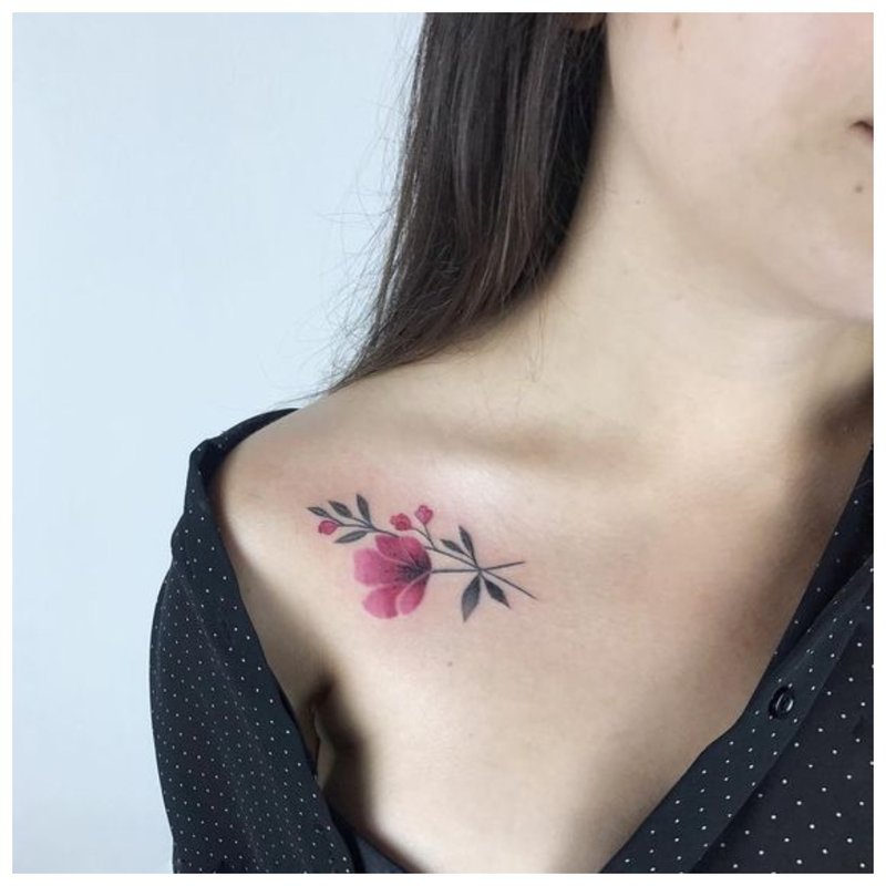 Delicate flower tattoo on the collarbone