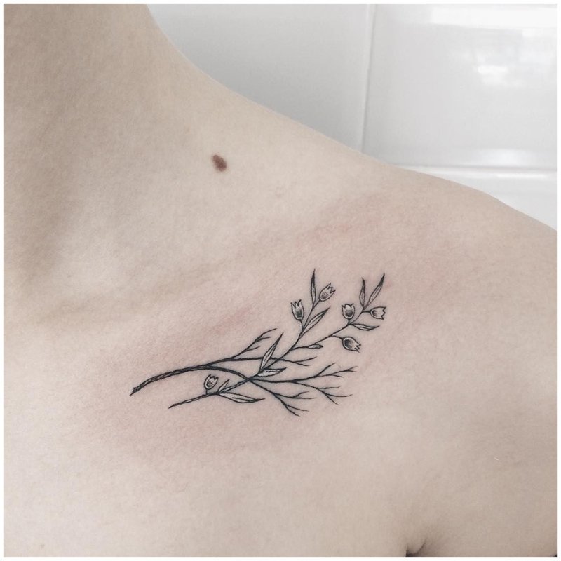 Black and white flower under the collarbone