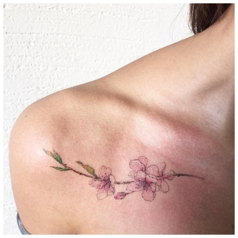 Delicate flower tattoo on the collarbone