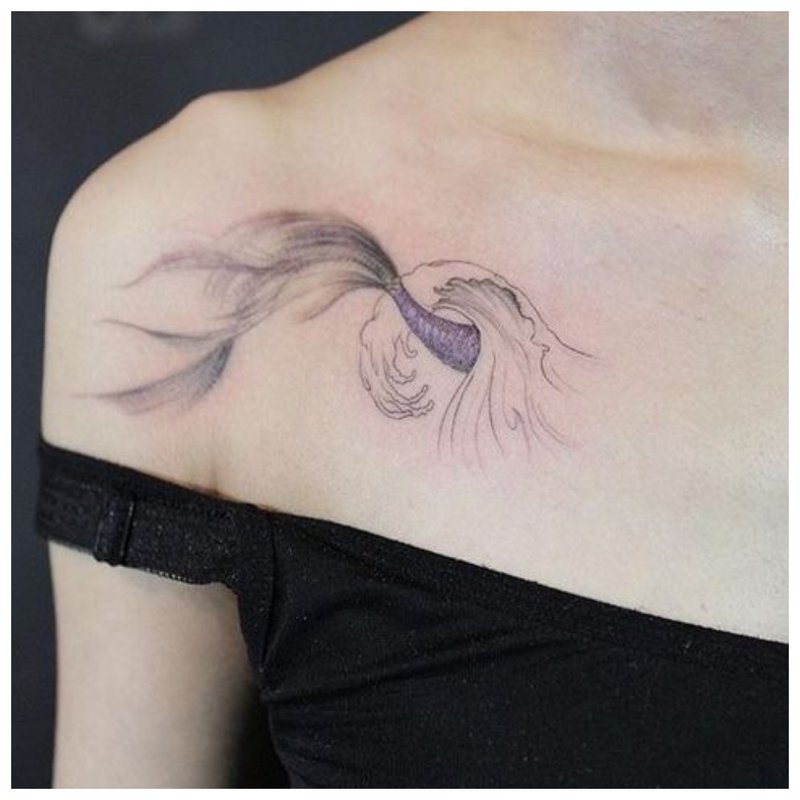 Unusual tattoo on the collarbone of a girl