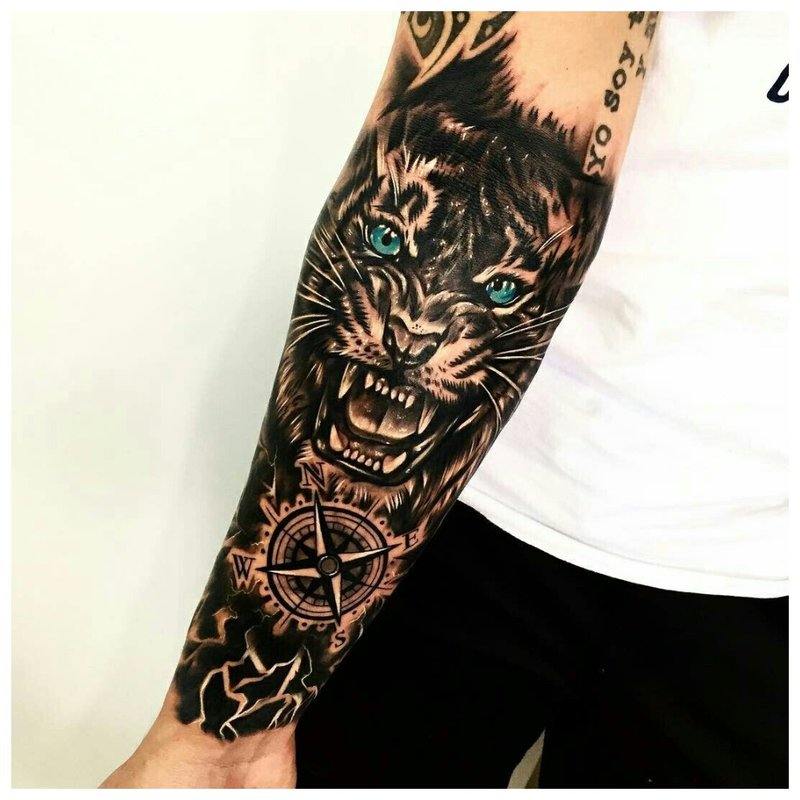 Angry lion - tattoo on the forearm of a man