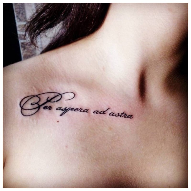 Tattoo inscription on the collarbone of a girl