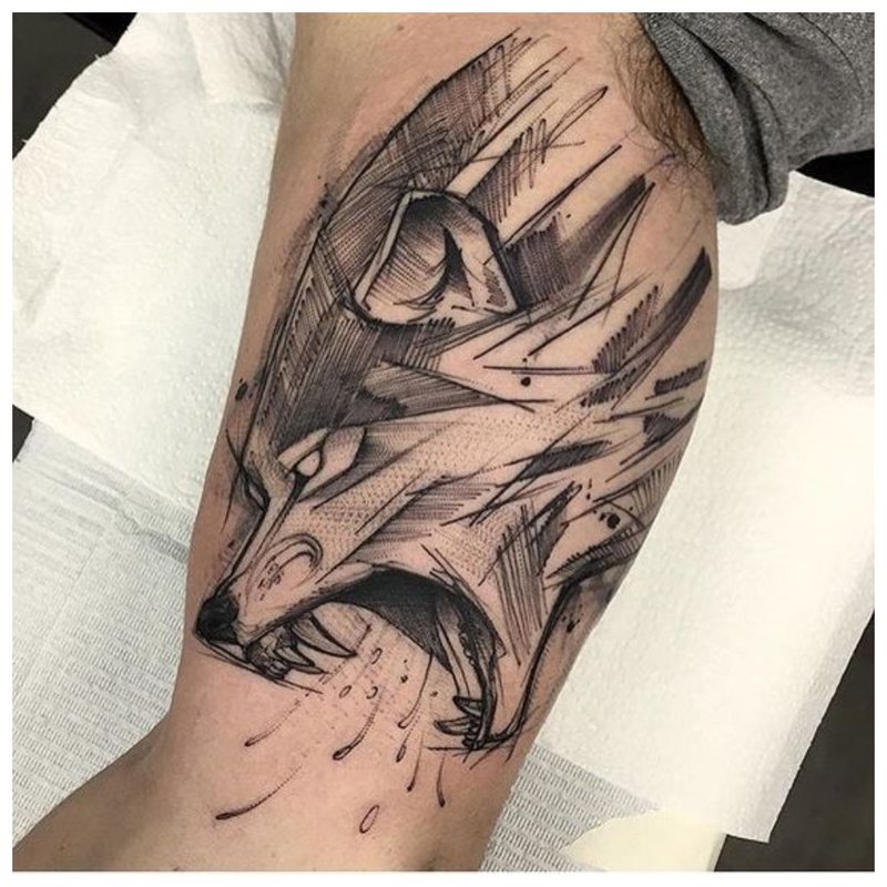 Wolf's mouth - a tattoo on a man’s body