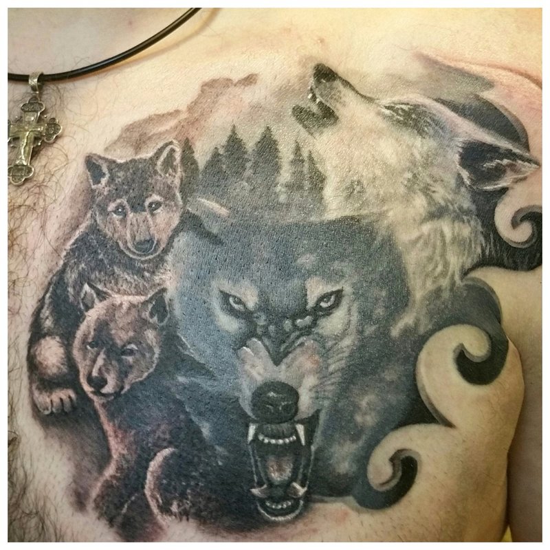 Wolf with his pack - tattoo on a man’s chest