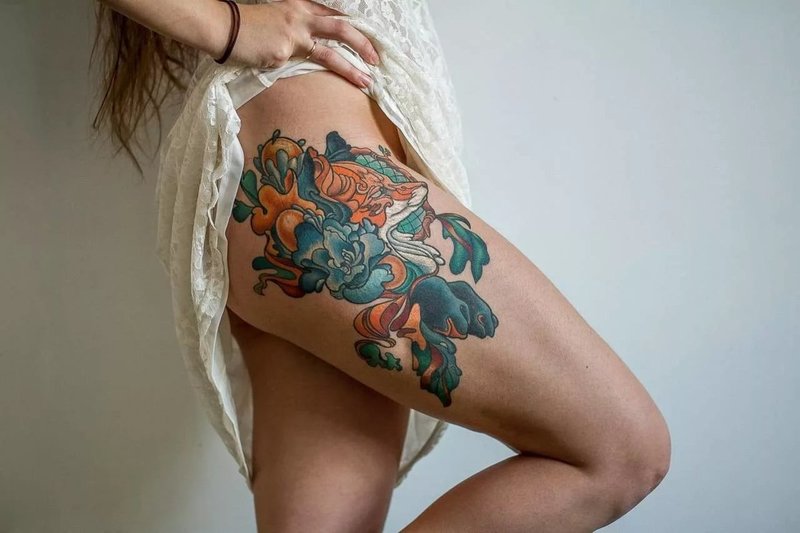 Colorful tattoo on the hip of a girl