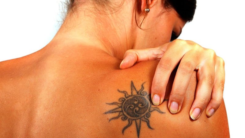 Girl with a tattoo after tanning