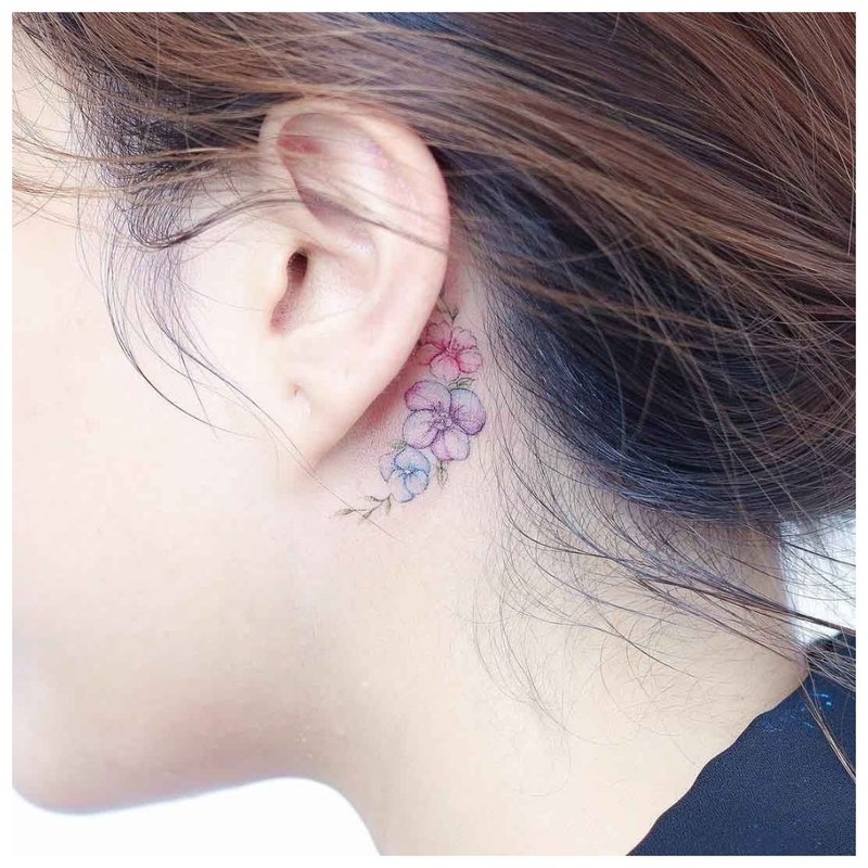 Delicate flower tattoo on the girl's neck