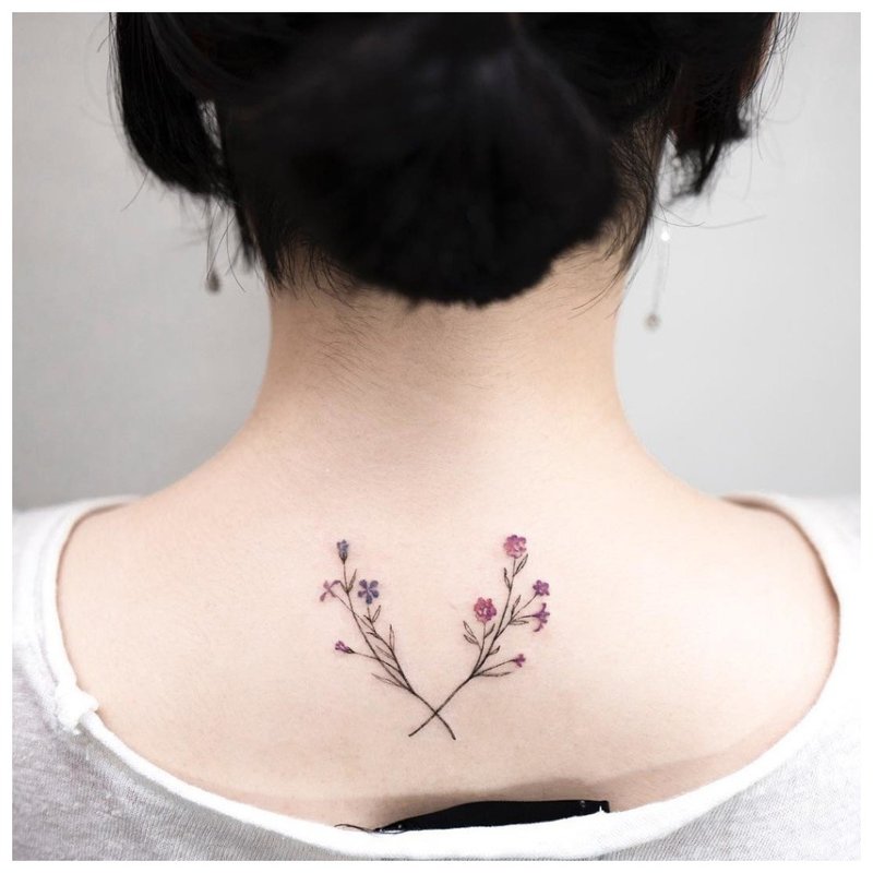 Delicate flowers - tattoo on the girl's neck on the back