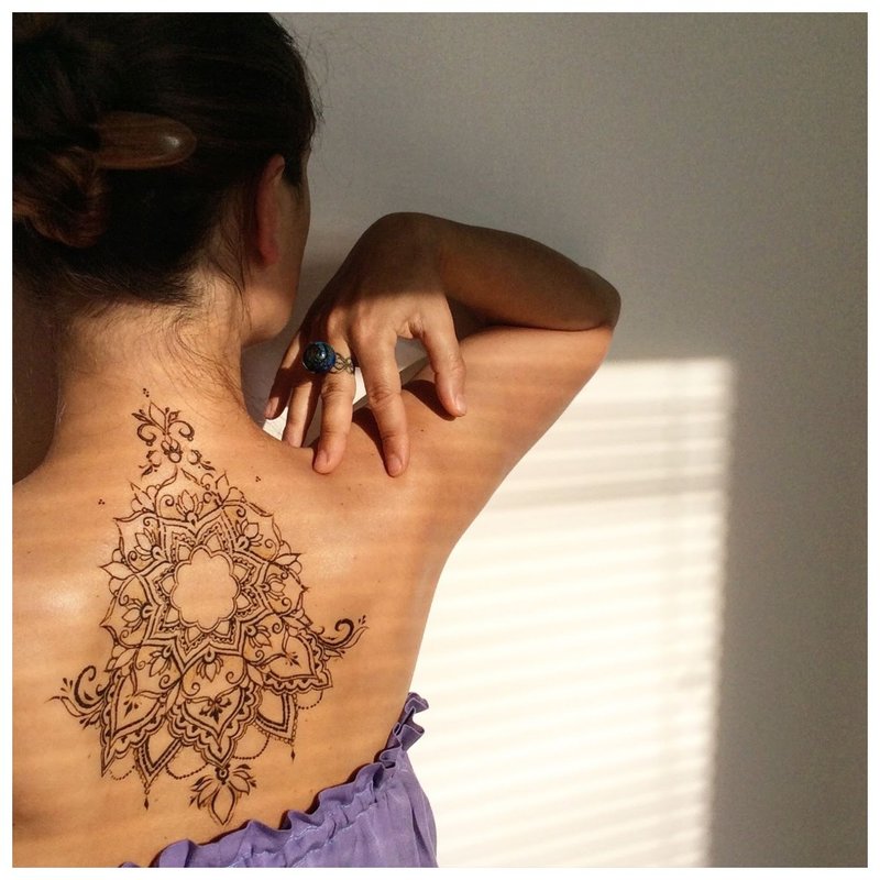 Unusual mehendi tattoo on the back